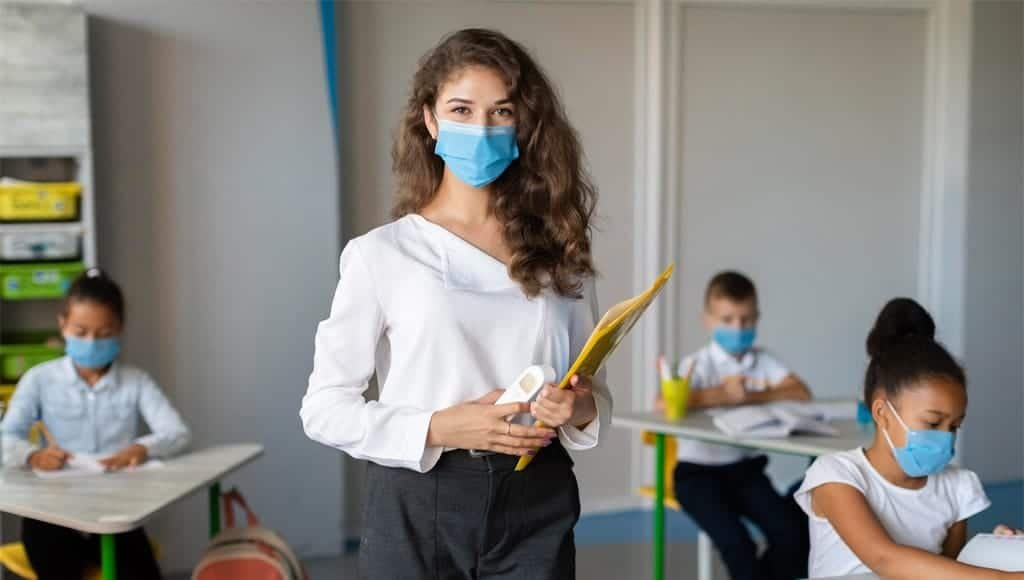 Seorang guru yang sedang memantau muridnya belajar